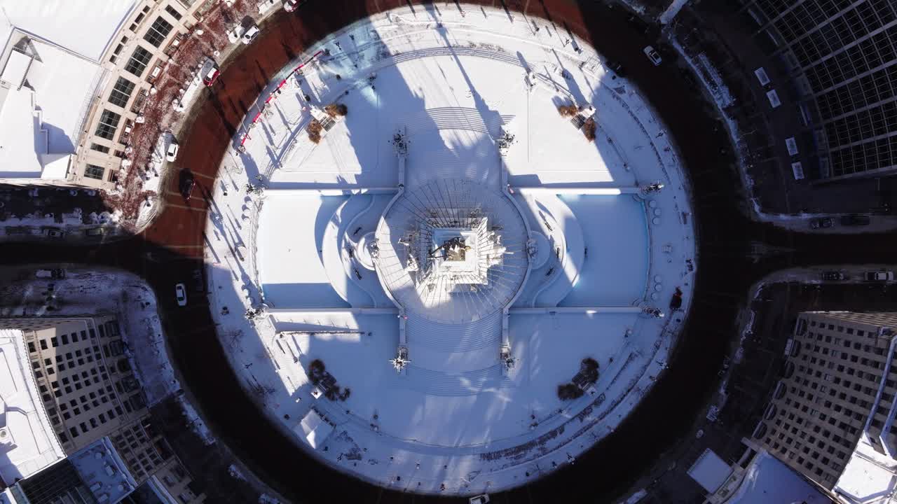 Ripresa aerea con braccio mobile che rivela Monument Circle in una fredda giornata invernale innevata a Indianapolis