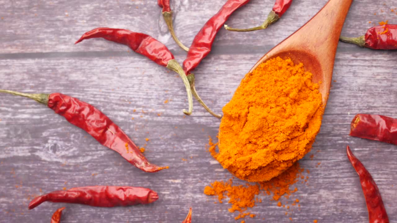 Dried Red Chili Peppers and Chili Powder in a Wooden Spoon