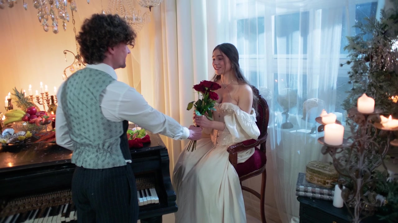 Man Presents Red Roses to Woman in a Romantic Vintage Room