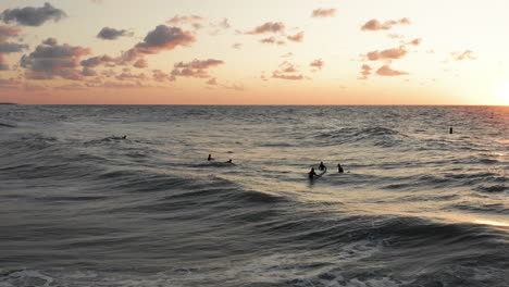 surfers in front of the touristic town domburg in the netherlands during sunset