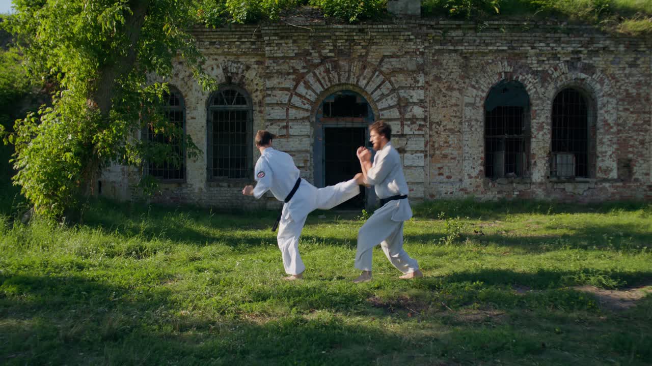 Due uomini che praticano karate all'aperto