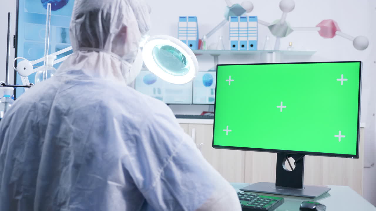 Scientist working in laboratory with green screen computer