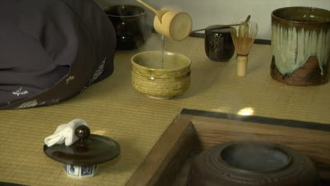 hot water is ladled from tetsubin kettle during a japanese tea ceremony