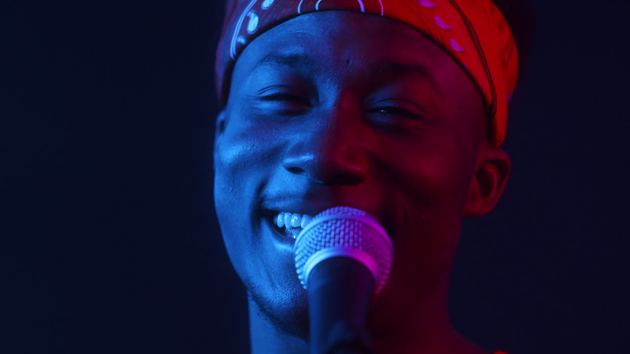 Man Singing Into a Microphone in a Vibrant Neon Light