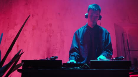 un dj moderno de apariencia asiática realiza una pista de música con iluminación de neón.