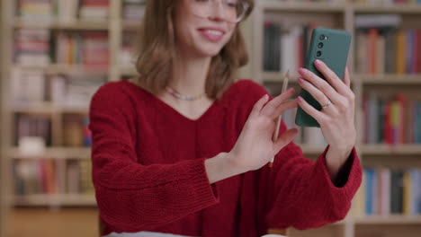 a happy young woman answers video call in library