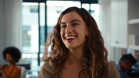 Close-Up-Portrait-Of-Young-Smiling-Businesswoman-Standing-In-Modern-Office