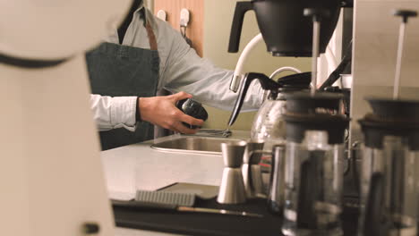 unrecognizable waiter washing coffee cup