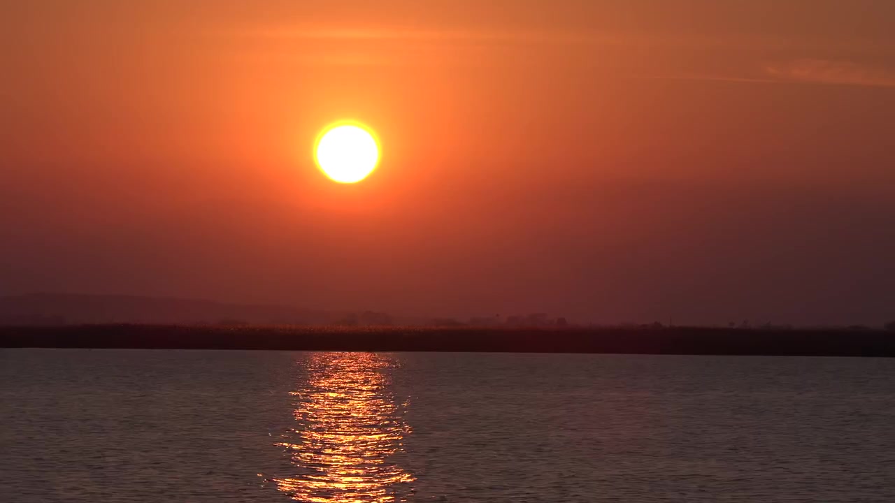 Senja Keemasan di Atas Danau Tenang dengan Pegunungan di Kejauhan