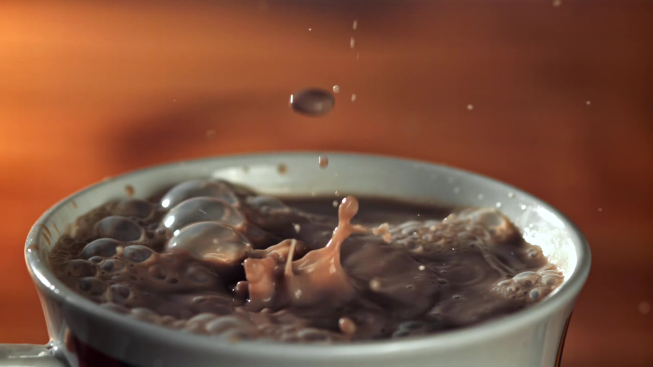Slow Motion Drops of Hot Chocolate Splashing into a White Mug