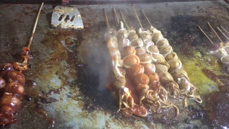 El-Vendedor-De-Comida-Callejera-Está-Haciendo-Una-Brocheta-De-Calamar-Asado-Con-Salsa-De-Tomate-Y-Chile