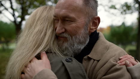 mature lovers hugging in the park at daytime