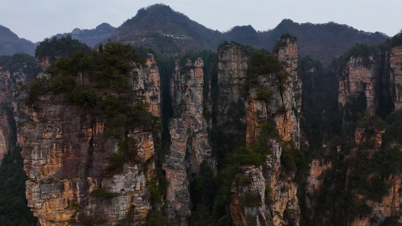 Imposing sandstone pillars rise from the lush forests of Zhangjiajie, creating a surreal and iconic landscape that captivates visitors with its natural grandeur.