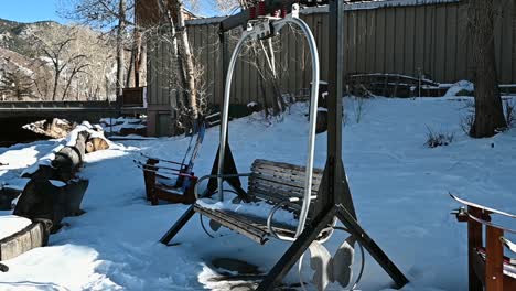 ski lift chair converted to a park bench with snow on it during the winter, handheld