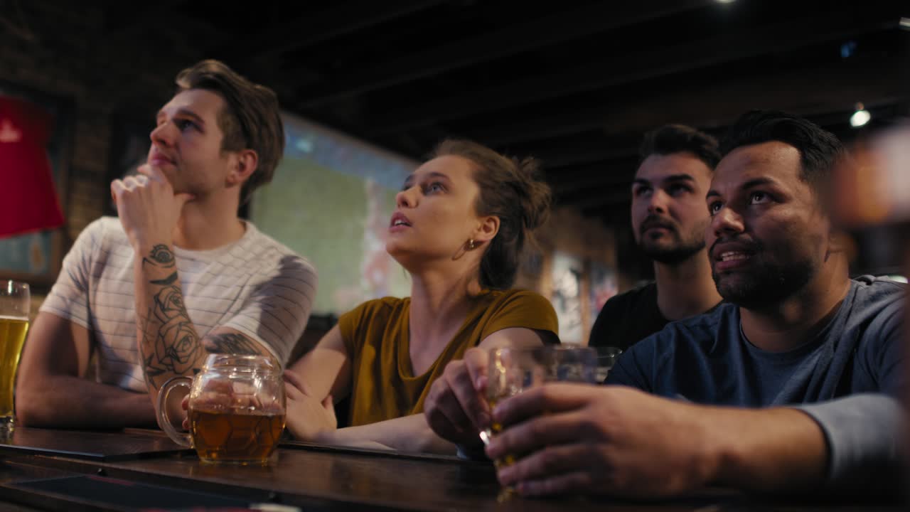 Gruppo di amici che fanno il tifo per una partita di calcio al pub