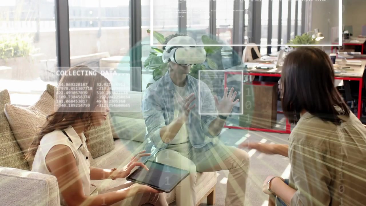 Uomo che indossa un visore VR bianco, gesticolando, un team tecnologico che usa un tablet, e ologrammi che analizzano i dati.