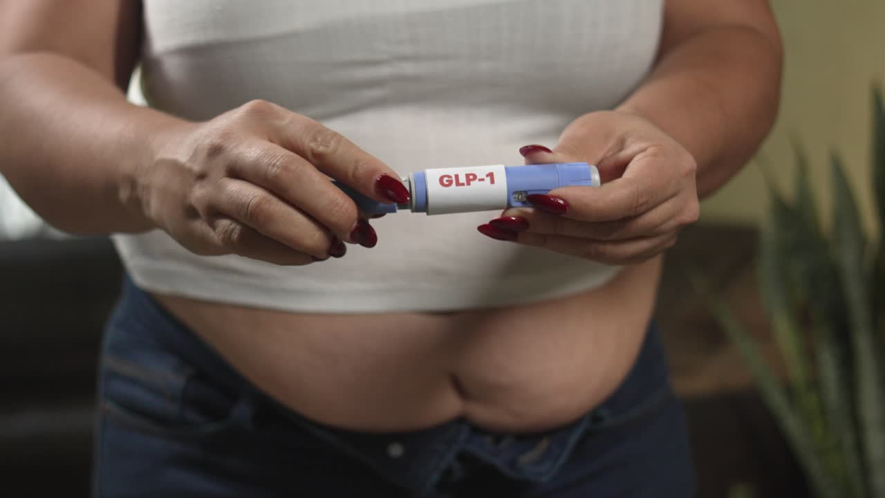 Mani femminili che preparano la penna di semaglutide GLP-1 per l'auto-iniezione, terapia per la salute metabolica e la perdita di peso.
