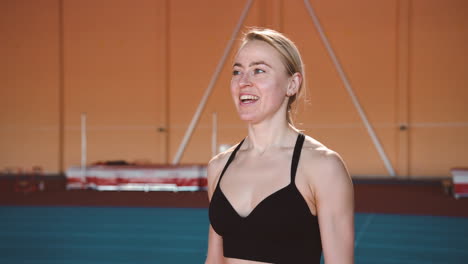 Happy-Blonde-Sportswoman-Jumping-And-Cheering-To-Celebrate-Victory-In-An-Indoor-Sport-Facility-2