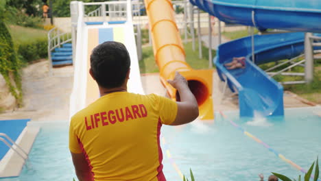 the rescuer is on duty at the water slides rear view 4k video