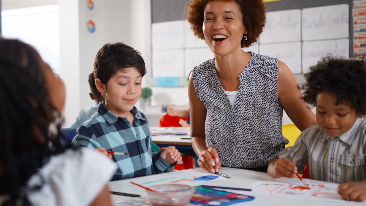 maestra con alumnos multiculturales de la escuela primaria en la clase de arte