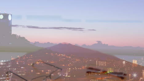 sección media del hombre de negocios y la mujer de negocios estrechando las manos contra la vista aérea del paisaje urbano por la noche