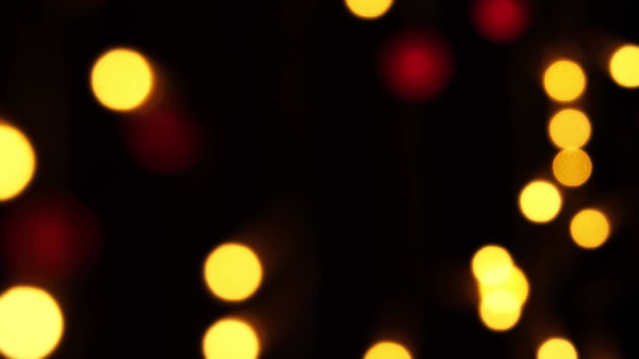 fondo bokeh abstracto en movimiento. brillantes, borrosas partículas multicolores, luces. bokeh brillante de guirnaldas en fondo oscuro. telón de fondo festivo de año nuevo o navidad