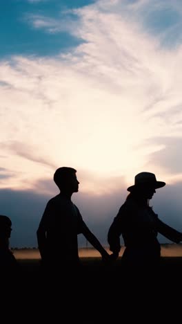 silhouettes of a loving family gathered together at a beautiful sunset in the evening a beautifully serene sunset silhouette depicting a loving family walking together in a peaceful landscape