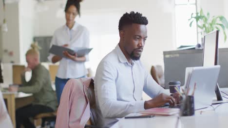 retrato de un feliz hombre de negocios afroamericano usando una computadora portátil en una oficina creativa