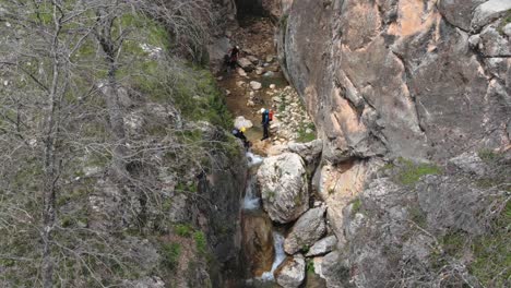 canyoning inside a ravine right next to a precipice and waterfall