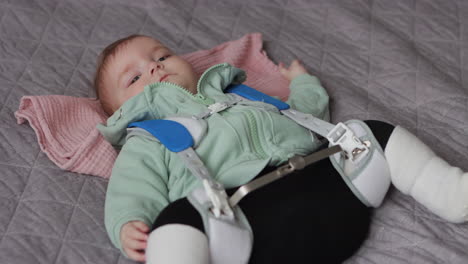 baby girl lying on back wearing pavlik harness to correct hip dysplasia