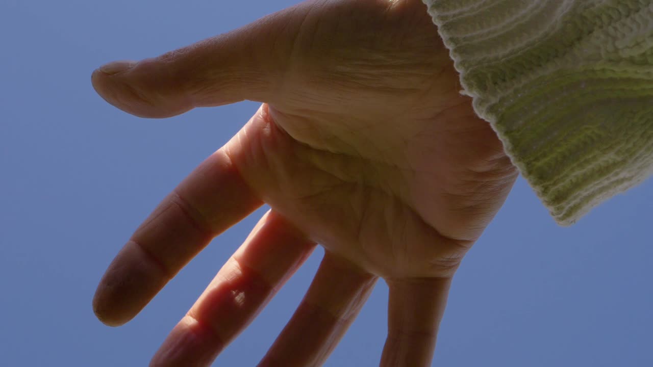 Single hand against blue sky medium shot