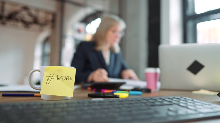 Businesswoman Working at Desk with Coffee Mug in Foreground