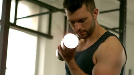 fit man lifting heavy silver dumbbells