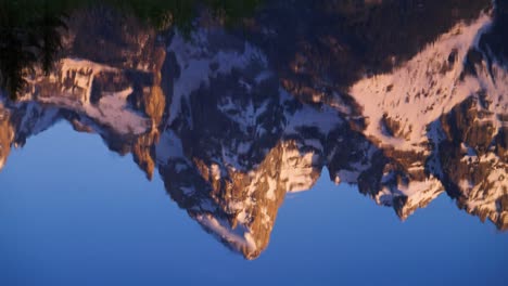 sunrise reflection and pan of mountains in river in grand teton national park, wyoming