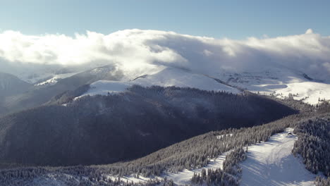 snow peaks rising through misty cloud cover, aerial perspective