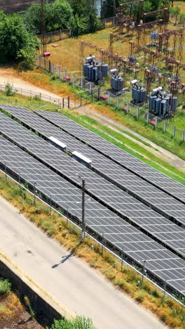 solar panels farm field of green renewable energy. powerful station with solar panels generates electric current with help of sunlight on field. orbital view vertical video