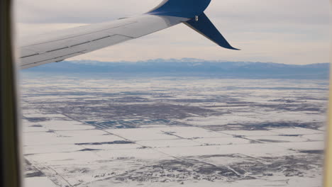 ala de avión en vuelo con las montañas rocosas al fondo.