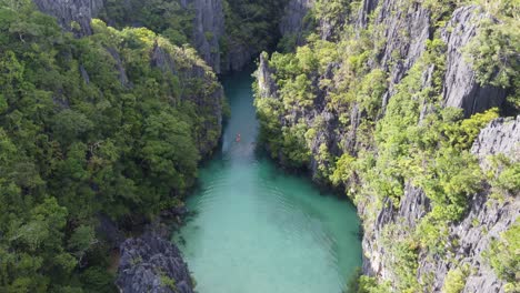 un kayakista en una pequeña laguna escénica con espectaculares afloramientos cársticos, el nido