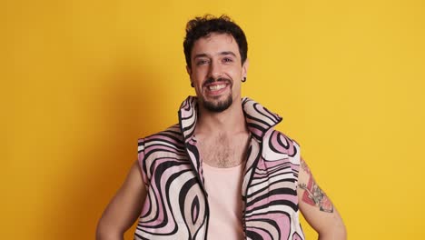 man with pink clothes and make up smiling at the camera