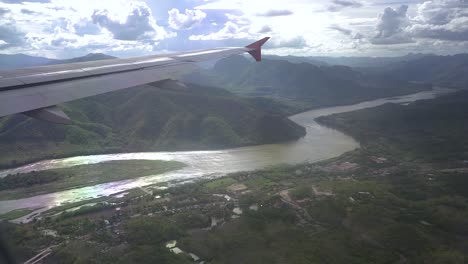 mirando fuera de la ventana del avión cuando el avión pasa el río mekong en laos