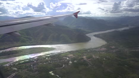 looking outside the airplane window when the plane is passing the mekong river in laos