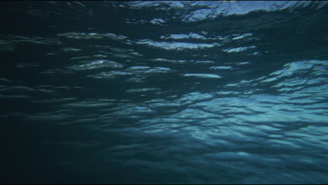 light blue streaks from ocean wave spread across as barrel forms