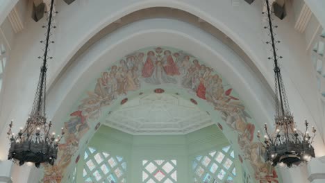 ornate interior of church with chandeliers and stained glass