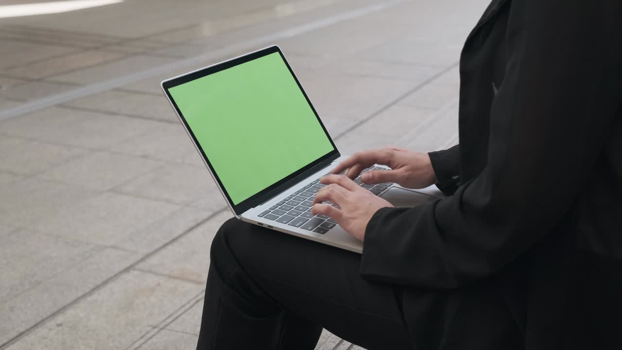 Business woman typing on laptop with green screen background,chroma key.