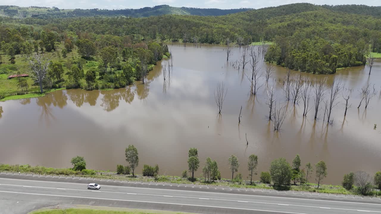 자동차는 경치 좋은 저수지 근처의 고속도로를 따라 이동합니다.