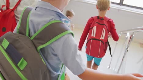 video de atrás de los niños caucásicos caminando por las escaleras de la escuela