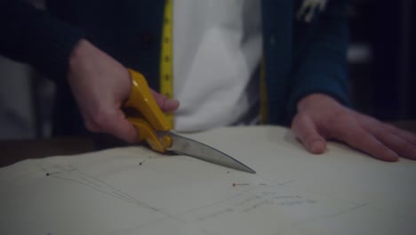 mid shot of person cutting white fabric and textiles in studio