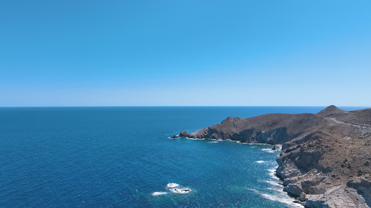 Aerial glides over dramatic national park coastal headland Punta de Loma Pelada