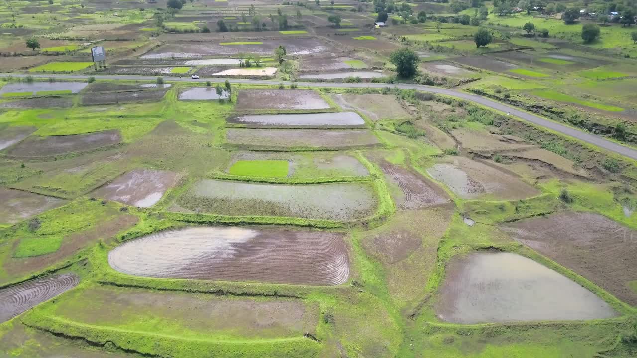 campos de arroz inundados en la zona rural de maharashtra, india, ascendiendo desde el aire