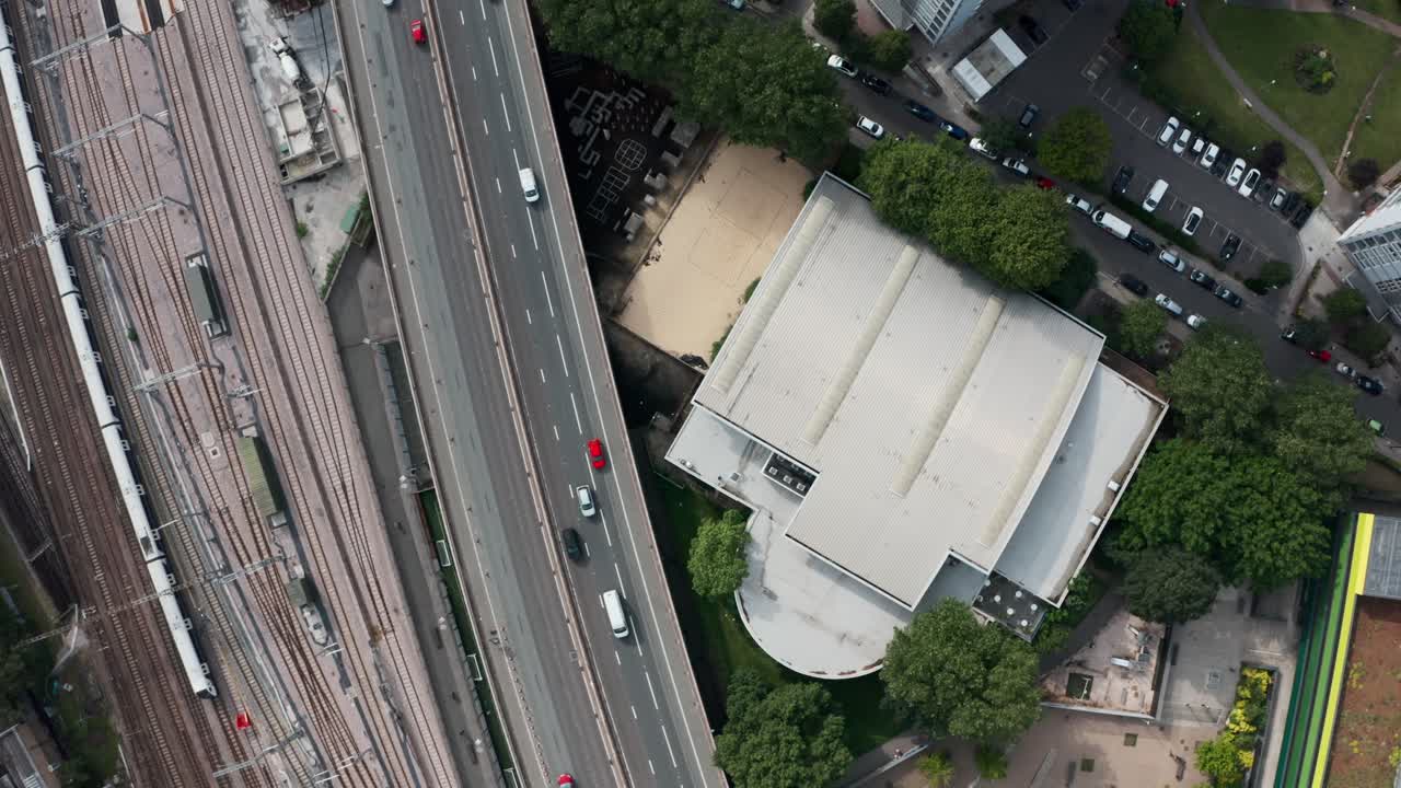 toma de drones de arriba hacia abajo de la concurrida carretera y la línea de tren cerca de la zona residencial